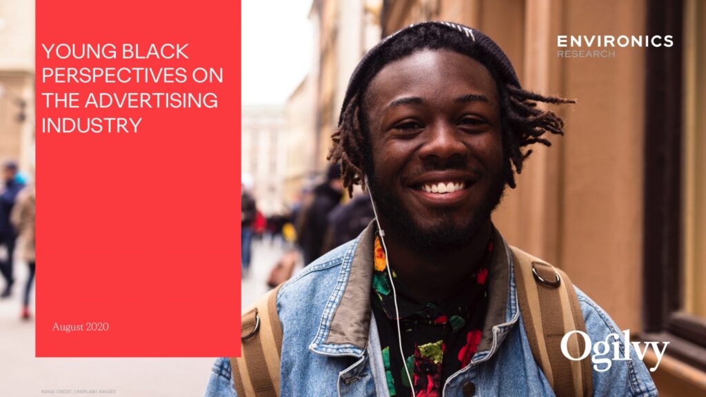 Young black male smiling outside on street.