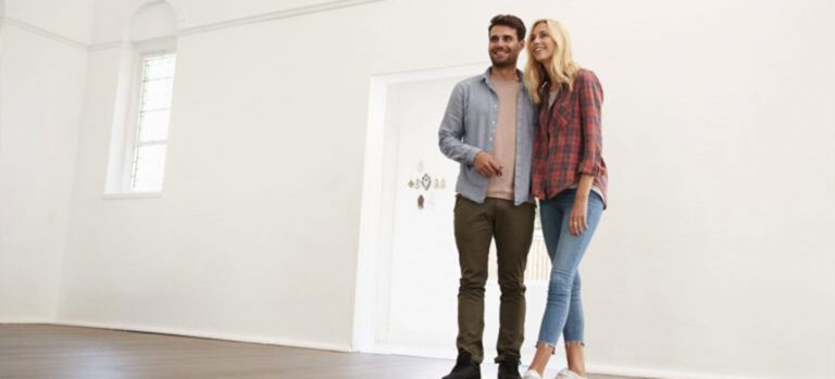 a millennial couple in an empty house