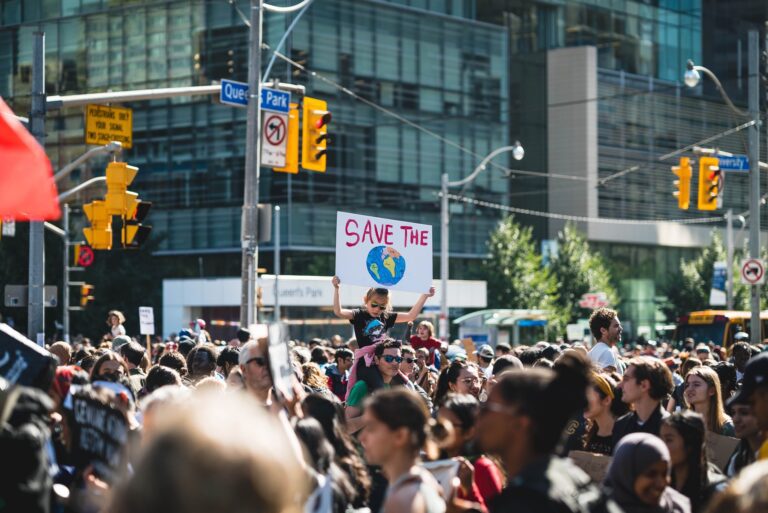 Wide environmental campaign - girl with save the world sign in Toronto