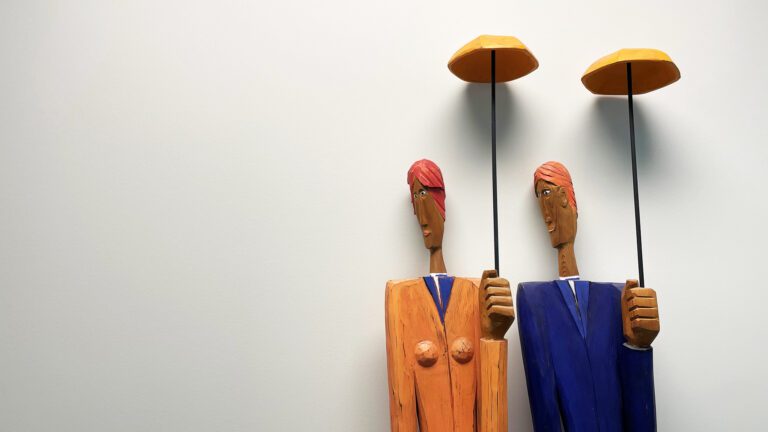 man and women sculpture with umbrellas