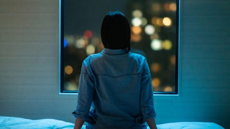 woman stressed staring out window at night