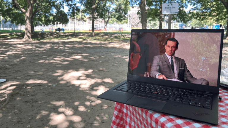 Image of Donald Draper on a laptop in the park