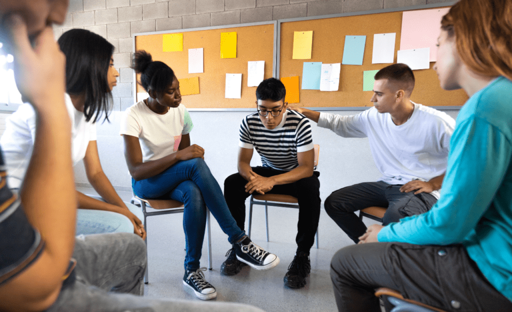 Students sitting in circle formation inside a university classroom.