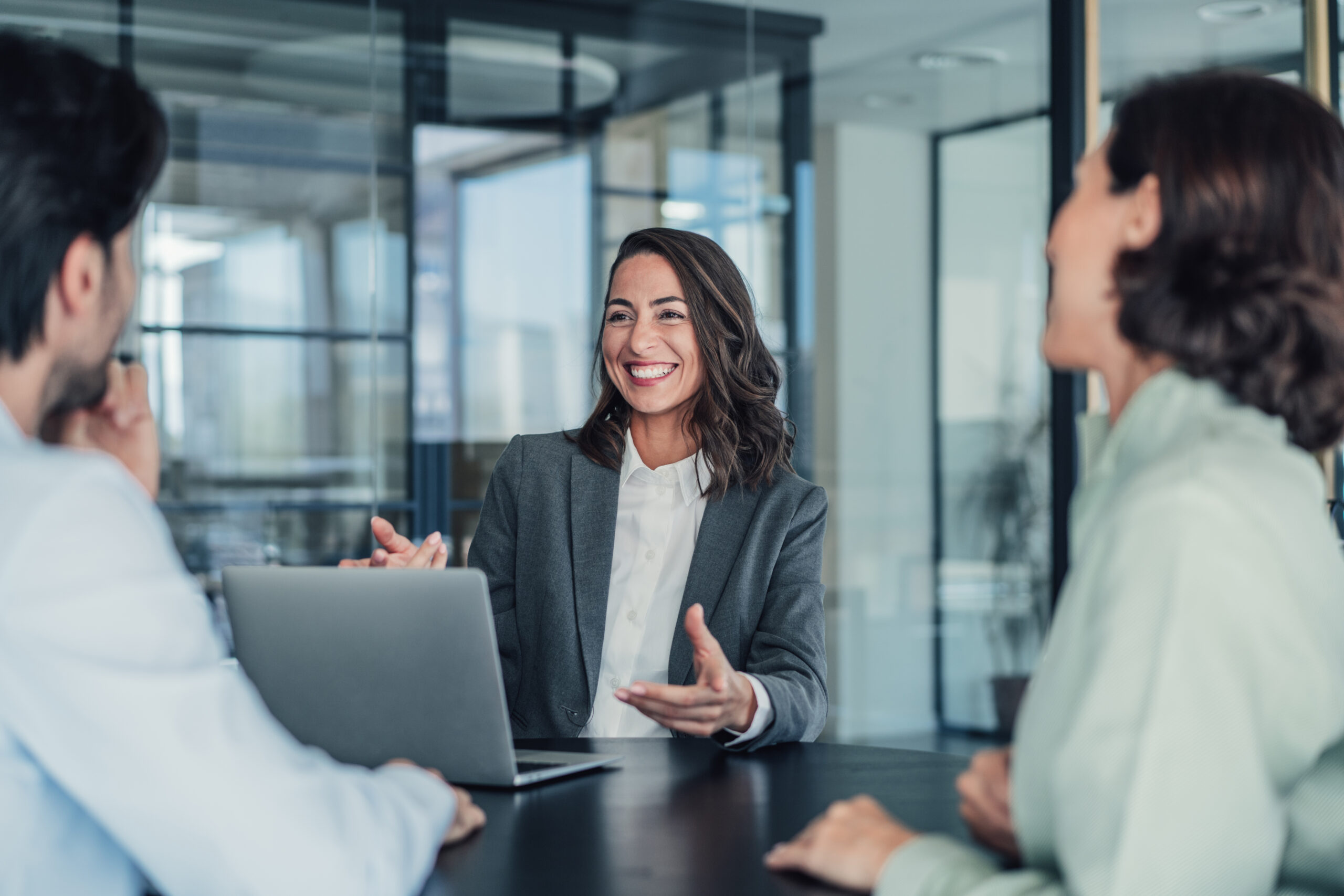 Shot of group of business persons in business meeting. Three entrepreneurs on meeting in board room. Corporate business team on meeting in modern office. Female manager discussing new project with her colleagues. Company owner on a meeting with two of her employees in her office.