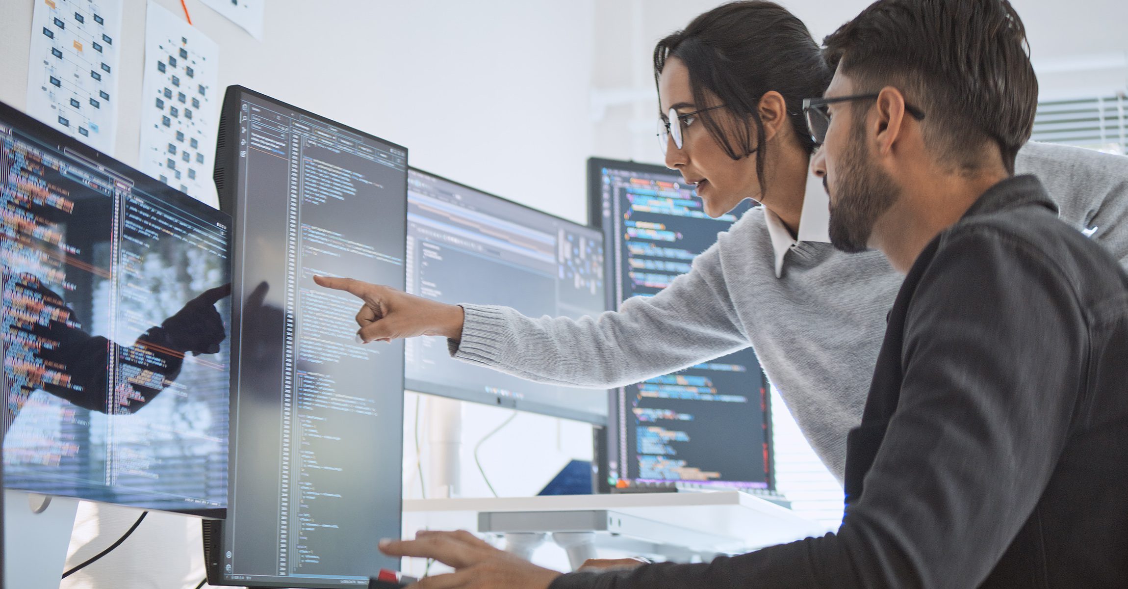 man and women looking at data on computer