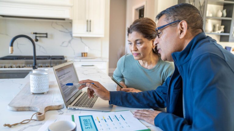 Man and woman planning financials on laptop
