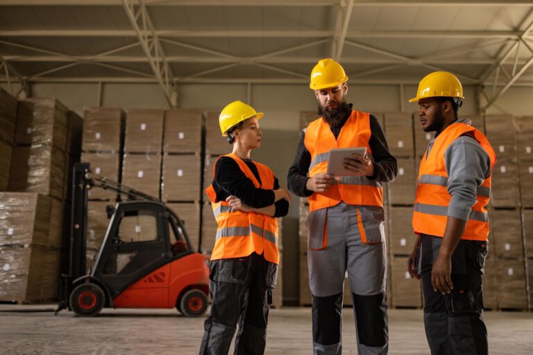 workers in warehouse with hardhats chatting