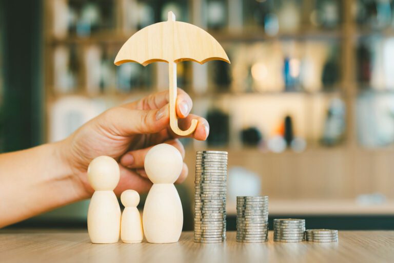 toy umbrella being held over family figurines and money
