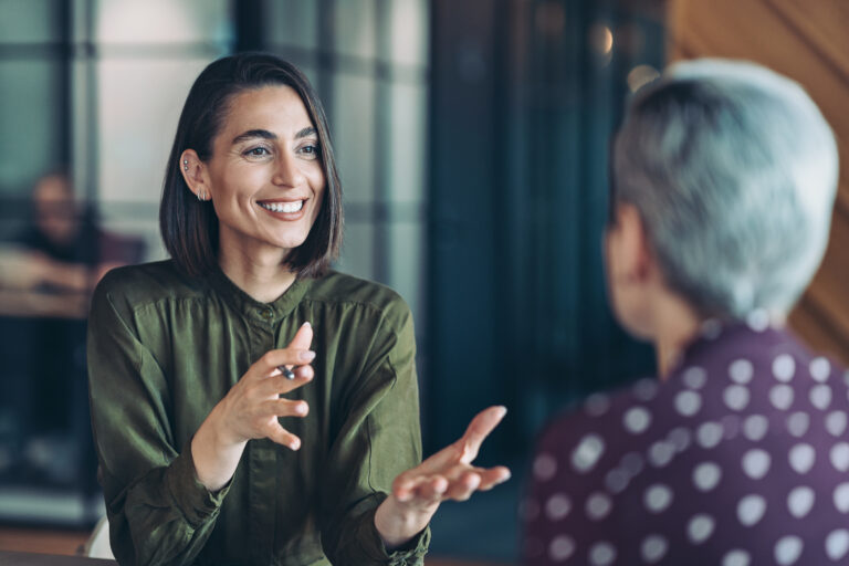 Two women working in an office talking