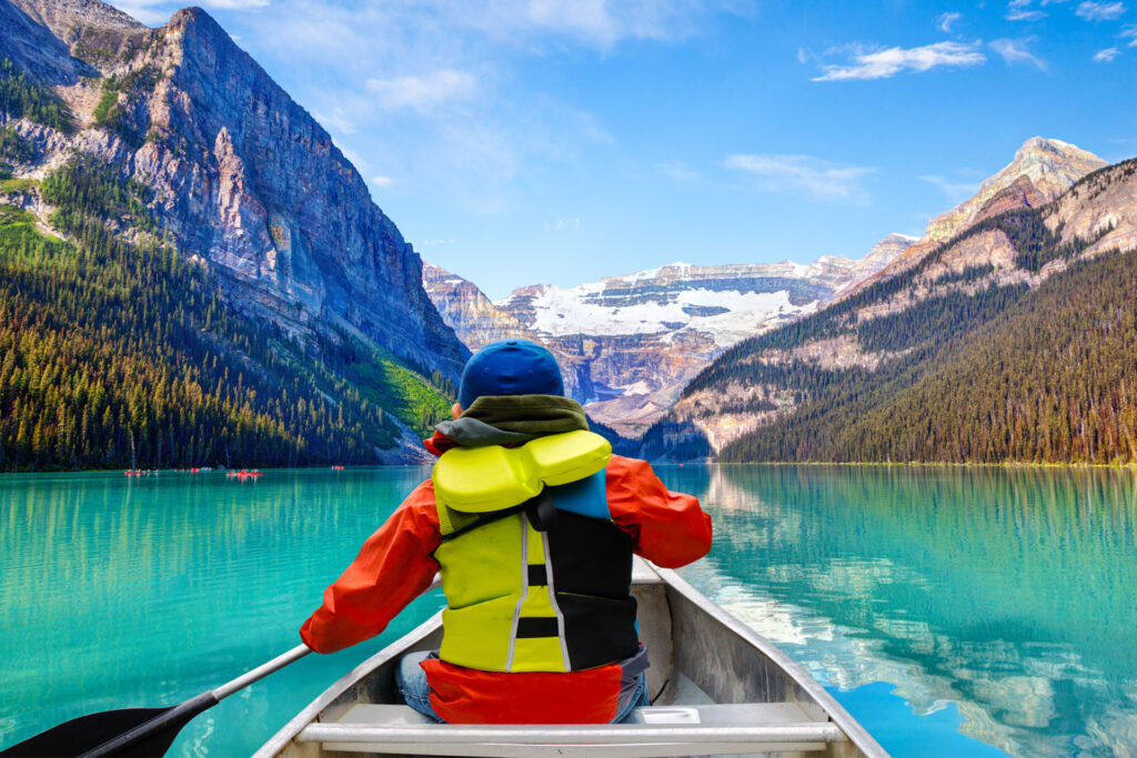 boy in canoe on lake in alberta