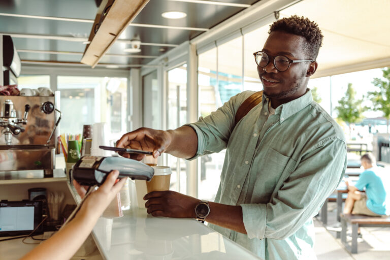 Man paying with phone in coffee shop