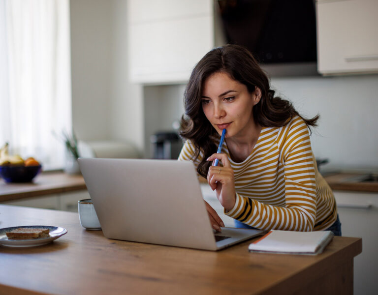woman banking online in kitchen