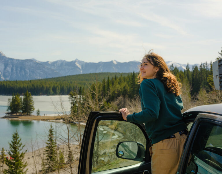 woman smiling by car in banff