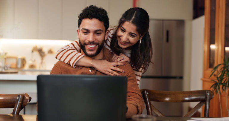 Couple using laptop in kitchen
