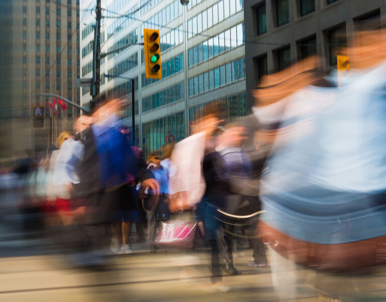 people crossing street in a blur