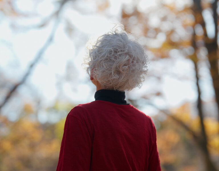 woman wearing red sweater in woods